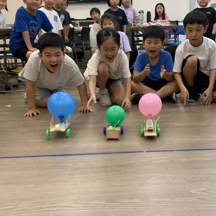 Children racing balloon-powered cars